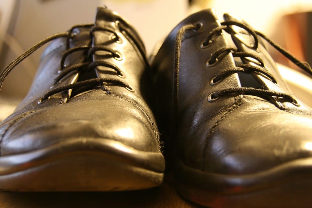 Close view of a pair of black leather shoes with a soft conditioned shine.